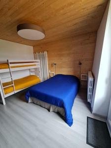 a bedroom with a blue bed and bunk beds at Gite du bibicherat in Largillay-Marsonnay