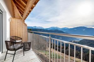 a balcony with a chair and a view of mountains at Reiterhof Apt Flora in San Genesio Atesino