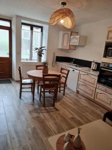 a kitchen with a table and chairs in a room at Gite du bibicherat in Largillay-Marsonnay +11 photos