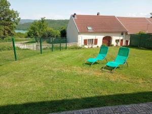 two chairs sitting in the yard of a house at Gite du bibicherat in Largillay-Marsonnay