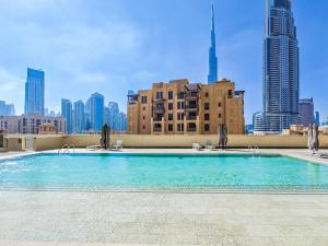 a swimming pool on top of a building with a city skyline at Lavishly Elegant 2BR with Breathtaking Full Burj Khalifa View in Dubai