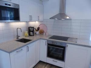 cocina blanca con fregadero y fogones en Mini-villa 200 m from Kampinge beach, en Höllviken