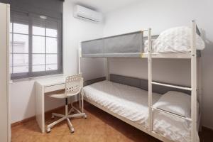 a dorm room with bunk beds and a desk at Apartamento Miramar in Cala del Moral