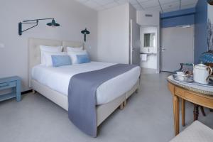 ein Schlafzimmer mit einem großen Bett und einem Tisch in der Unterkunft Hôtel Le Grand Barnum in Francheville