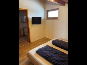 a small bedroom with a bed and a television at NEU! FeWo Mansi in Chiemgau in Kienberg
