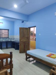 a bedroom with two beds and a bathroom at Kenchas Beach Resort in Gokarna