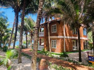 a brick house with palm trees in front of it at Kega Lighthouse Resort Bình Thuận in Ke Ga