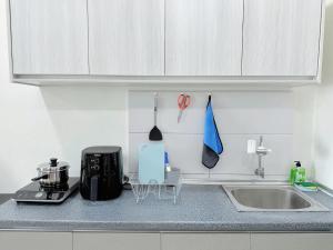 eine Küche mit einer Arbeitsplatte mit einer Spüle und einer Theke von 6 dx in der Unterkunft The Octagon Ipoh in Ipoh