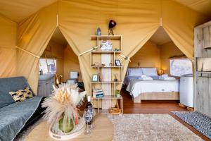 Zimmer mit einem Zelt mit einem Bett und einem Tisch in der Unterkunft Civara Chalet - Private Glamping in nature with Jakuzzi in Tsivarás