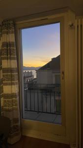 a window with a view of the sunset from a balcony at Lake view studio in Lausanne