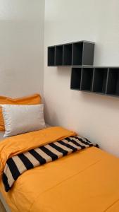 una camera con due letti arancioni a righe bianche e nere di Lake view studio a Losanna