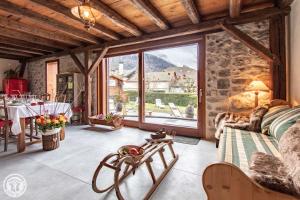 Una sala de estar con una mesa y una gran ventana. en Les Gîtes Chapô Julô, en Giez