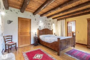 Un dormitorio con una cama de madera y un techo de madera. en Les Gîtes Chapô Julô, en Giez