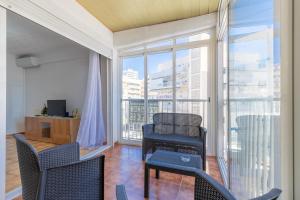 ein Wohnzimmer mit Stühlen und einen Balkon mit Aussicht in der Unterkunft Larisa Apartment in Benidorm