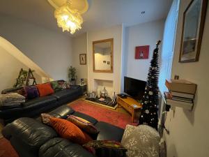 a living room with a couch and a christmas tree at Tudor House in Leicester