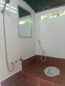a bathroom with a shower with a toilet in it at Pirates Arms Backpackers in Kampot