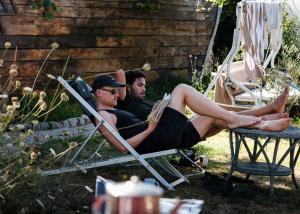 two men sitting in lawn chairs in the yard at Maceda Surf Camp in Maceda