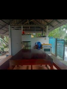 a kitchen with a table in the middle of a room at Pirates Arms Backpackers in Kampot