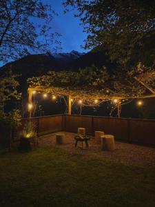 un patio trasero con una mesa de picnic y luces por la noche en Pension St. Ursula, en Saltusio