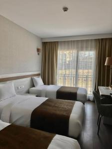 KarabukにあるKanyonvadi Hotelのベッド3台と窓が備わるホテルルームです。