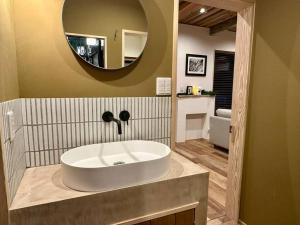a bathroom with a white sink and a mirror at The Misorano Cottage in Hakuba