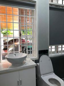a bathroom with a sink and a toilet and a window at Nhat Long Homestay in Hue