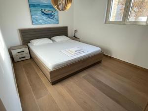 een slaapkamer met een bed en een houten vloer bij Lux apartment Amarin in Pržno