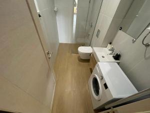 een witte badkamer met een toilet en een wastafel bij Lux apartment Amarin in Pržno
