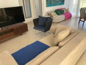 a living room with a couch and a television at Village dos Ipês in Praia do Forte