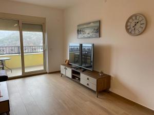 een woonkamer met een tv en een klok aan de muur bij Lux apartment Amarin in Pržno