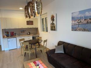 a living room with a couch and a table and a kitchen at Lux apartment Amarin in Pržno