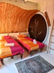 two beds in a room with a wall at Maceda Surf Camp in Maceda