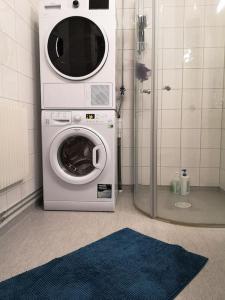 uma máquina de lavar e secar roupa na casa de banho com chuveiro em Stor lägenhet för familj eller företag em Norrköping