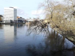 a view of a river with buildings in the background at Stor lägenhet för familj eller företag in Norrköping