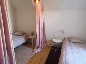 a bedroom with two beds and pink curtains at Stor lägenhet för familj eller företag in Norrköping