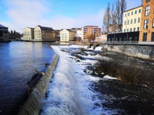 une rivière avec de la neige sur son côté dans l'établissement Stor lägenhet för familj eller företag, à Norrköping