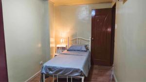 - une petite chambre avec un lit et une porte dans l'établissement Ormoc City Gate 2 Apartment, à Ormoc