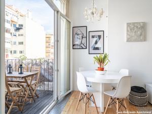 um pequeno apartamento com uma varanda com uma mesa branca e cadeiras em Akicity Ourique Selected em Lisboa