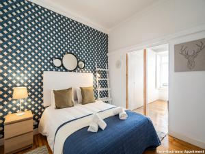 um quarto com uma parede estampada em azul e branco em Akicity Ourique Selected em Lisboa