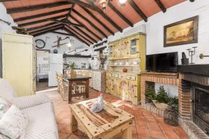 a living room with a fireplace and a table at Cortijo rural las aves in Jimena de la Frontera