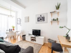 uma sala de estar com um sofá, uma televisão e uma mesa em Akicity Ourique Selected em Lisboa