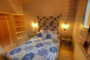 1 dormitorio con 1 cama en una habitación de madera en chalet 3 étoile La bresse avec sauna, en La Bresse