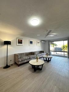 a living room with a couch and a table at Tranquil Scape-Villa with Pool by Gold Coast Premium in Gold Coast