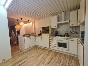een keuken met witte kasten en een houten vloer bij Gasthuis In't Stad in Nieuwpoort