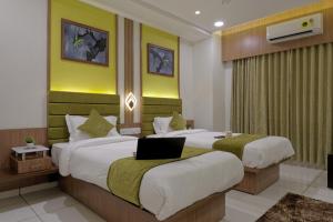 pokój hotelowy z 2 łóżkami i laptopem w obiekcie HOTEL COMFY w mieście Unjha
