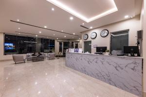 a lobby with a counter and clocks on the wall at Towlan Qurtuba 2 in Riyadh