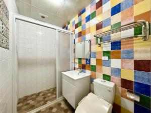 baño con aseo y una pared de azulejos de colores. en Tenho Homestay, en Lukang
