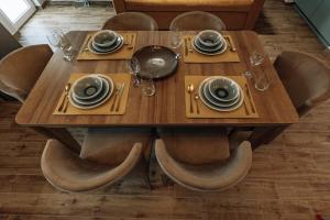 a wooden table with plates and dishes on it at AnnaG apart in Athens