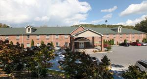 una vista aérea de un gran edificio de ladrillo con aparcamiento en Mountain Inn & Suites Airport - Hendersonville, en Hendersonville