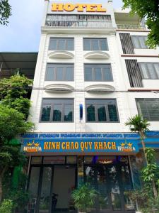 um edifício branco com um cartaz em Hoàng Gia Đông Anh Hotel em Dong Anh